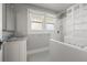 Bathroom featuring a tub/shower combo with a glass block partition and vintage fixtures at 864 15Th Ne Ave, St Petersburg, FL 33704