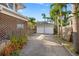 Driveway leading to a two-car detached garage surrounded by lush landscaping at 864 15Th Ne Ave, St Petersburg, FL 33704