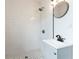 Renovated bathroom featuring a walk-in shower and modern vanity with a round mirror at 1316 Barry St, Clearwater, FL 33756