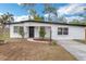 Charming single-story home with a well-maintained lawn, brick walkway, and black front door at 1316 Barry St, Clearwater, FL 33756