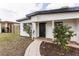 Well-kept single story home with a brick walkway, manicured bushes, and a black front door at 1316 Barry St, Clearwater, FL 33756