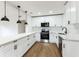 Modern kitchen featuring stainless steel appliances, white cabinets, marble countertops and wood floors at 1316 Barry St, Clearwater, FL 33756