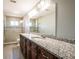 Bathroom featuring double sinks, granite countertop, and tiled walk-in shower at 1375 Corner Oaks Dr, Brandon, FL 33510