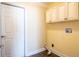 Laundry room with upper cabinets, tile flooring and yellow walls at 1375 Corner Oaks Dr, Brandon, FL 33510