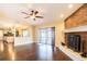 Open-concept living room with hardwood floors, brick fireplace, and access to the kitchen at 1375 Corner Oaks Dr, Brandon, FL 33510