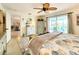 Bedroom showcasing beach-themed decor, a unique ceiling fan, and plenty of natural light, creating a tranquil space at 13801 Plumosa Ave, Hudson, FL 34667