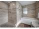 Modern bathroom featuring tiled walls, glass-enclosed shower, and separate tub with window at 1415 54Th N Ave, St Petersburg, FL 33703