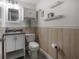 Half bathroom with wood paneling, white vanity and toilet at 1415 54Th N Ave, St Petersburg, FL 33703