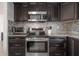 Kitchen detail showing stainless steel appliances, granite countertops, overhead microwave and brown cabinets at 1415 54Th N Ave, St Petersburg, FL 33703