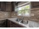 Granite countertops and tile backsplash surround a stainless steel sink and appliances in this home's kitchen at 1415 54Th N Ave, St Petersburg, FL 33703