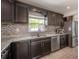 Close-up on kitchen with stainless steel appliances, granite countertops, modern backsplash and brown cabinets at 1415 54Th N Ave, St Petersburg, FL 33703