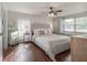 Bright main bedroom featuring wood-look floors, accent wall, ceiling fan and lots of natural light at 1415 54Th N Ave, St Petersburg, FL 33703