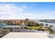 Panoramic aerial view of a waterfront community with townhouses, tennis courts, and boat docks under a blue sky at 1651 Sand Key Estates Ct # 53, Clearwater, FL 33767