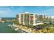 Waterfront condominium building with boat docks and covered parking surrounded by palm trees at 1651 Sand Key Estates Ct # 53, Clearwater, FL 33767
