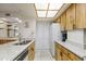 Bright kitchen with stainless steel appliances, granite countertops, wood cabinets and white tile flooring at 1651 Sand Key Estates Ct # 53, Clearwater, FL 33767