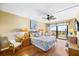 Bedroom with wood floors, ceiling fan, balcony, and ocean view at 1651 Sand Key Estates Ct # 53, Clearwater, FL 33767