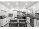 Contemporary kitchen with gray wood floors, white cabinets, stainless steel appliances, and modern lighting at 1661 Grove St, Clearwater, FL 33755