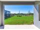 Scenic backyard view from covered patio, showcasing lush green lawn and a serene water view with a black metal fence at 17802 Everlong Dr, Land O Lakes, FL 34638