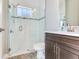Modern bathroom features glass door shower, neutral walls and tile flooring and brown vanity at 17802 Everlong Dr, Land O Lakes, FL 34638