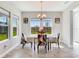 Sunlit dining room with modern decor, stylish chairs, and a view of the backyard through large windows at 17802 Everlong Dr, Land O Lakes, FL 34638