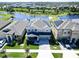 Beautiful two-story home featuring solar panels, a well-manicured lawn, and a serene lakeside view at 17802 Everlong Dr, Land O Lakes, FL 34638