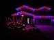 Charming two-story home adorned with vibrant purple and red Christmas lights at night at 17802 Everlong Dr, Land O Lakes, FL 34638
