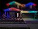 Festive two-story home illuminated with vibrant, colorful Christmas lights and manicured lawn at 17802 Everlong Dr, Land O Lakes, FL 34638