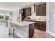 Spacious kitchen features dark wood cabinets, a white countertop island with seating, and stainless steel appliances at 17802 Everlong Dr, Land O Lakes, FL 34638