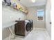 Modern laundry room with updated appliances, tile flooring, and a bright window, offering a clean and efficient space at 17802 Everlong Dr, Land O Lakes, FL 34638