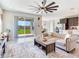Bright living area with backyard views, a modern ceiling fan, and comfortable seating at 17802 Everlong Dr, Land O Lakes, FL 34638