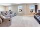 Well-lit living room features a comfortable gray reclining sofa and multiple bright windows, creating an inviting space at 17802 Everlong Dr, Land O Lakes, FL 34638