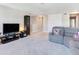 Comfortable living room with a gray reclining sofa, television, and ample space for relaxation and entertainment at 17802 Everlong Dr, Land O Lakes, FL 34638