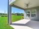 Covered patio with a ceiling fan overlooking the lush backyard and scenic pond at 17802 Everlong Dr, Land O Lakes, FL 34638
