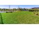 Spacious backyard with a tranquil lake view, enclosed by a black metal fence, providing both beauty and security at 17802 Everlong Dr, Land O Lakes, FL 34638