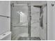 Modern bathroom featuring a glass-enclosed shower, with white marble tiling and dark accents at 1828 Bough Ave # 3, Clearwater, FL 33760