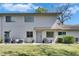 Charming condo with well-maintained lawn, vibrant bushes, and a cozy outdoor seating area near the front door at 1828 Bough Ave # 3, Clearwater, FL 33760