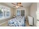 Bedroom with a ceiling fan, shuttered windows, and a light blue patterned bedspread at 2005 Harvard Ave, Dunedin, FL 34698