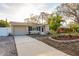 Charming single-story home with landscaped yard and well-maintained lawn at 2005 Harvard Ave, Dunedin, FL 34698