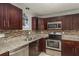 Well-appointed kitchen featuring granite countertops, stainless steel appliances and dark wood cabinetry at 2005 Harvard Ave, Dunedin, FL 34698