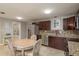 Spacious kitchen with stainless steel refrigerator, granite counters, and adjoining dining area at 2005 Harvard Ave, Dunedin, FL 34698