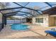Beautiful pool area with brick pavers, a screened enclosure, and outdoor seating at 2005 Harvard Ave, Dunedin, FL 34698