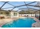 Enclosed pool with brick patio, seating, and sunshades, creating a comfortable outdoor living area at 2005 Harvard Ave, Dunedin, FL 34698