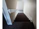 Carpeted stairs with white banisters leading to an upper level at 202 Brigadoon Dr, Clearwater, FL 33759