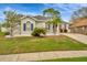 Charming single-story home featuring lush lawn, mature landscaping, and a welcoming front porch at 23137 Emerson Way, Land O Lakes, FL 34639