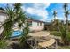Backyard with a patio area, outdoor dining set, and tropical landscaping. Kayaks in disrepair are visible at 2501 Auburn S St, St Petersburg, FL 33712