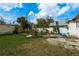 Spacious backyard features lush green lawn, mature palm trees and a concrete patio at 2501 Auburn S St, St Petersburg, FL 33712