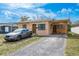 Modest single-story home with gravel driveway and a car parked in front, under a partly cloudy sky at 2501 Auburn S St, St Petersburg, FL 33712