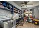 Functional kitchen with blue cabinets, white appliances, tile floors, and open shelving at 2501 Auburn S St, St Petersburg, FL 33712