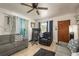Bright living room with tile flooring, ceiling fan, sofas, and a view of the front entrance at 2501 Auburn S St, St Petersburg, FL 33712
