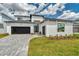 Modern home featuring a black garage door, monochromatic color scheme, and paver driveway at 32347 Wetland Bird Vw, San Antonio, FL 33576